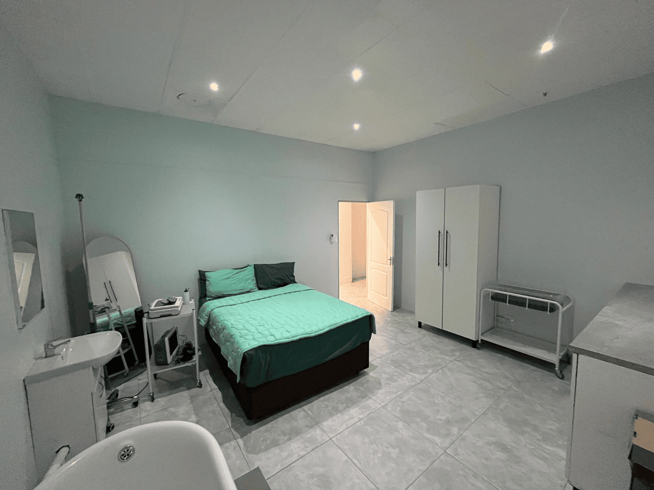Private maternity room with turquoise bedding and birthing bath